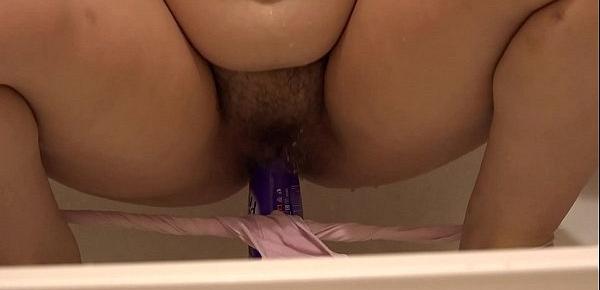  The brunette in the shower stall let down her wet panties and fucked her hairy pussy with a bottle.